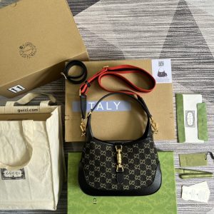 This small handbag features black leather trim and the collection's iconic gold push-lock hardware